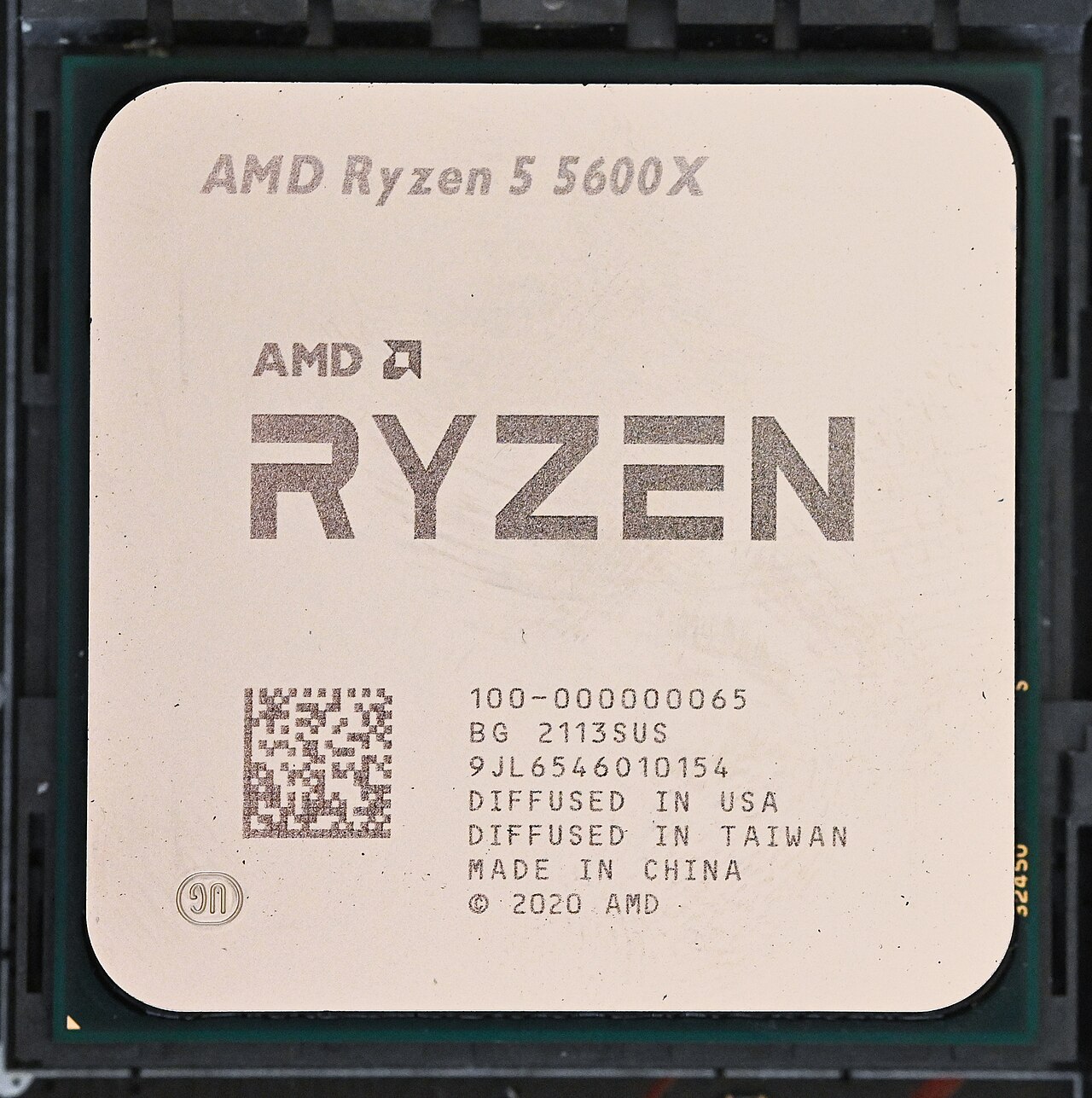 Procesador AMD Ryzen 5 5600X colocado en el zócalo de una placa base, visto desde arriba, con el modelo grabado en la tapa metálica